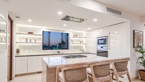 A modern kitchen with a large island, built-in appliances, and a large window. - 3bd Condo Ocean Views Pool HK - Tower 5 (Punta de Mita)