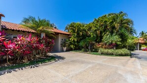 A residential area with a paved driveway, palm trees, and a house with a tiled roof. - 3 Bd Villa in Las Palmas Punta Mita Cook Golf-cart - Las Palmas 5 (Punta de Mita)