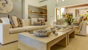 Ein modernes Wohnzimmer mit einer Sofagarnitur, einem Couchtisch und Dekorationselementen.