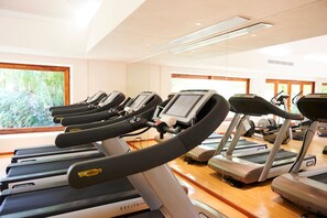 A gym with multiple treadmills arranged in rows, large windows with a view of greenery, and a clean, modern interior. - 4 bd Beach Chic Villa Ocean View - Iyari B4 (Punta de Mita)