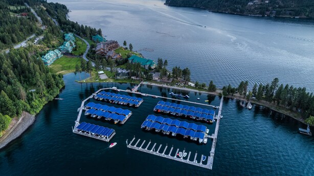 An aerial view of a lakeside property with a marina, docked boats, and a large building with a green roof. - Mountain Lake Getaway (Harrison)