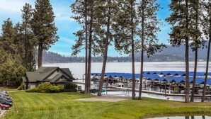 A lakeside property with a dock, boats, and a building with a sloped roof. - Mountain Lake Getaway (Harrison)
