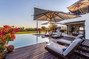 An infinity pool with lounge chairs and umbrellas, a wooden deck, and a view of the landscape. - 3bed- Ocean View Private Pool - Casa de las Aves Casita Zen 14 (Punta de Mita)