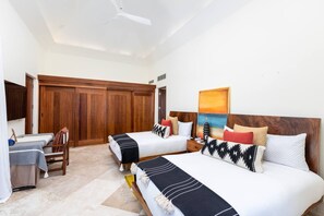 Ein Hotelzimmer mit zwei Betten, einem Holzschrank, einem Schreibtisch mit Stuhl und einem Bild an der Wand.