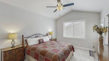 A bedroom with a bed, nightstands, a ceiling fan, a window with blinds, and a dresser.