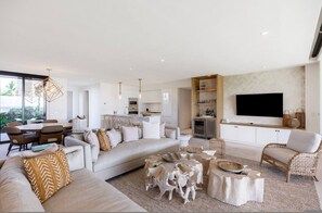 A modern living room with a sofa, coffee table, and TV. - Las Marietas D101 Punta Mita Private Pool (Punta de Mita)