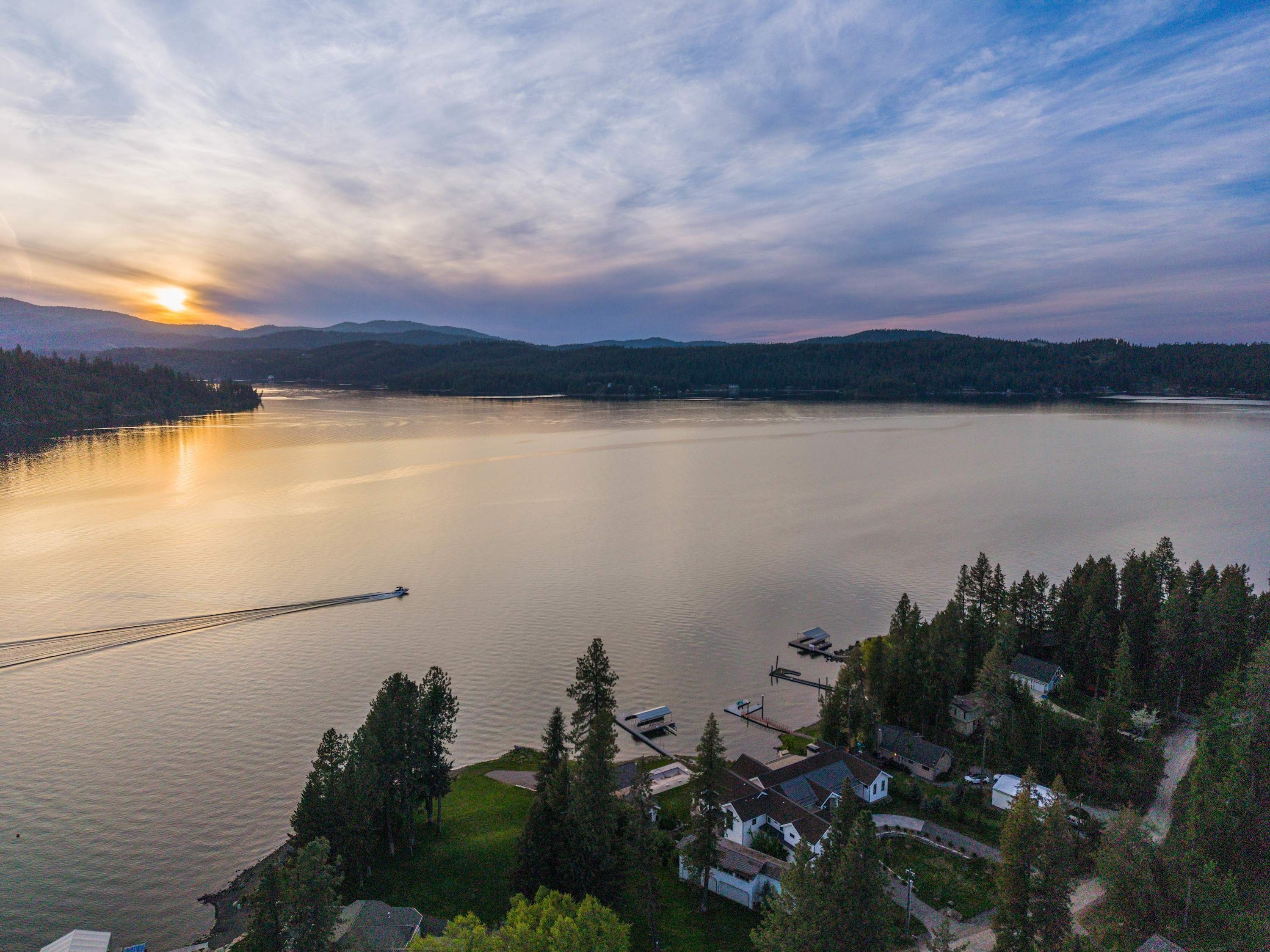 Un lac avec un quai, entouré de maisons et d’arbres.