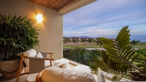 Un balcon avec vue sur un terrain de golf et sur des montagnes lointaines.
