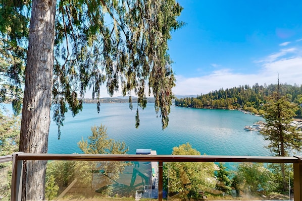 A view from a balcony overlooking a lake with trees and a dock. - Deja View - Upper Unit (Hayden)