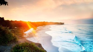 A beach with a row of white umbrellas, a sandy shore, and waves. - Gorgeous Remodeled Hacienda de Mita Condo - HDM 905 (Punta de Mita)