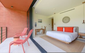 A bedroom with a bed, two chairs, a desk, and a dining table. - Naya 5201 Tower V in Punta De Mita (Punta de Mita)