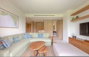 A modern living room with a sectional sofa, a wooden coffee table, and a flat-screen TV. - Naya 5201 Tower V in Punta De Mita (Punta de Mita)