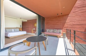 A modern bedroom with a bed, a sofa, and a dining area with chairs and a table. - Naya 5201 Tower V in Punta De Mita (Punta de Mita)