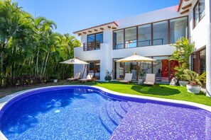 A modern two-story house with a swimming pool, outdoor seating, and lush greenery. - 4 bd Villa Serenata 6 With Private Pool (Punta de Mita)