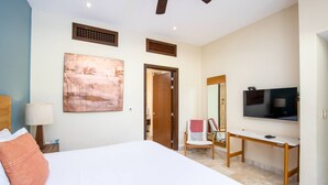 Una habitación de hotel con cama, escritorio, televisión y silla.