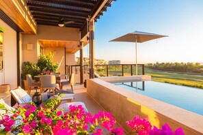 A rooftop terrace with a pool, outdoor seating, and a view of a golf course. - Lux 3 Bed Condo With Ocean View Pool Houskeeping (Punta de Mita)