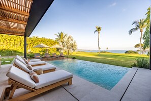 A pool area with lounge chairs, a wooden pergola, and a view of the ocean. - Serene Luxury - Private Pool Ocean View Cook Lagos 16 (Punta de Mita)