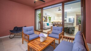 A modern living room with a sofa, chairs, a coffee table, and a ceiling fan. - Luxury 2 Bed 2 Bath Beachfront Condo - Bucerias (Bucerías)
