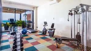 A gym with exercise equipment, a bench, and a view of the ocean. - Luxury 2 Bed 2 Bath Beachfront Condo - Bucerias (Bucerías)