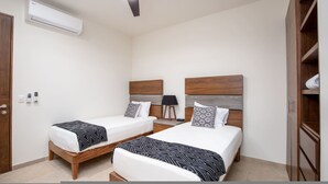 A bedroom with two beds, an air conditioning unit, a bedside lamp, and a wardrobe. - Luxury 2 Bed 2 Bath Beachfront Condo - Bucerias (Bucerías)