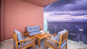 A balcony with a view of the sea, a wooden table, and two sofas. - Luxury 2 Bed 2 Bath Beachfront Condo - Bucerias (Bucerías)