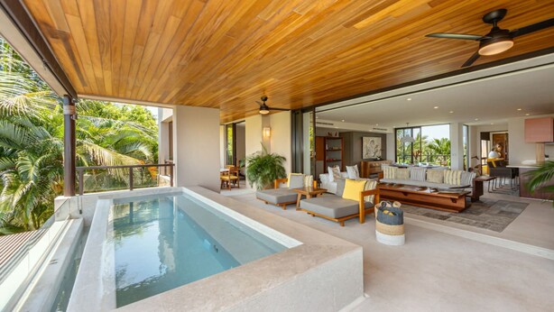 A modern indoor pool area with a wooden ceiling, seating, and a view of the outdoors. - 3 Bed 3 5 Bath Condo With Hsk Pool Ocean View (Punta de Mita)