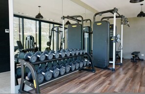 Ein Fitnessstudio mit Gewährleistungsausrüstung, Kurzhanteln und Trainingsgeräten.