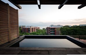 Ein Pool auf dem Dach mit Blick auf Gebäude und Grünflächen.
