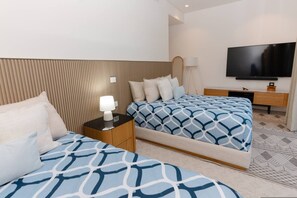 A hotel room with two beds, a TV, a bedside table with a lamp, and a patterned rug. - Naya 2101 Tower II in Punta De Mita (Punta de Mita)