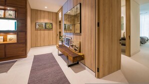 Un intérieur moderne avec un banc en bois, des œuvres d’art et un miroir au mur.