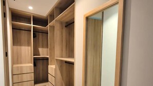 A walk-in closet with wooden shelving and a large mirror. - Naya 4101 Tower IV in Punta De Mita (Punta de Mita)