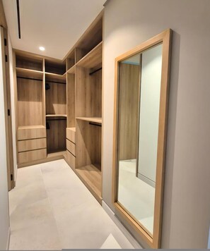 A walk-in closet with wooden shelving and a large mirror. - Naya 4101 Tower IV in Punta De Mita (Punta de Mita)