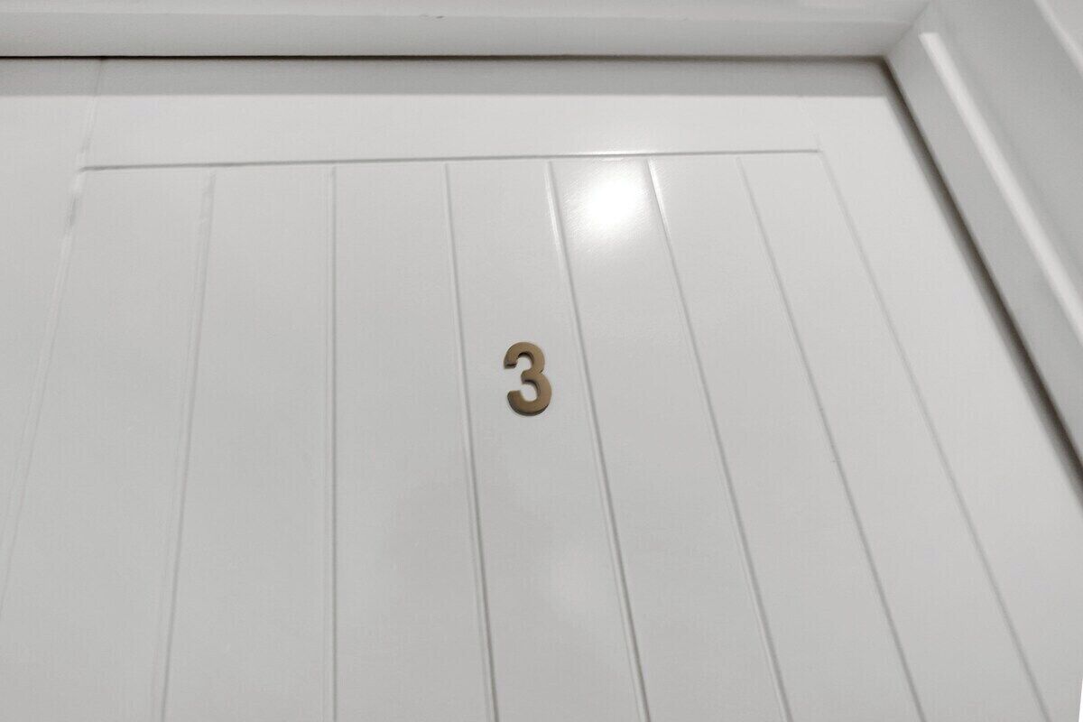 A white door with a brass number '3' indicating room number.