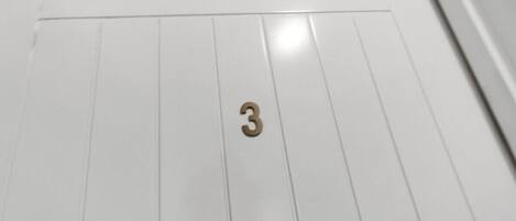 A white door with a brass number '3' indicating room number.