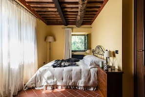 A bedroom with a bed, a dresser, a lamp, and a window with curtains. - Deluxe View Apartment in Borgo di Matraia (Capannori)