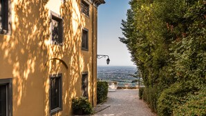 A pathway leading to a building with a view of a distant landscape. - Deluxe View Apartment in Borgo di Matraia (Capannori)