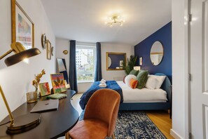 A modern bedroom with a bed, desk, chair, and a view of the city. - Greenwich Station 1 min Walk Big Ben 12 min (London)