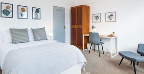 A bedroom with a bed, a desk, a chair, and a wardrobe. - Cosy King Room in Hanwell 10 Minutes to Station (London)