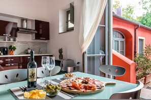 A modern kitchen with a marble countertop, a wine bottle, and a variety of food items on a table. - Superior Garden Borgo di Matraia (Capannori)