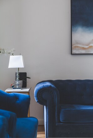 A room with a blue sofa, a white lamp on a side table, and a framed abstract painting on the wall. - Spacious Modern 3 Beds 3 Baths in Finchley (London)