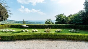 Un giardino curato con arredi da esterno disposti con ordine e una vista libera sul paesaggio circostante.