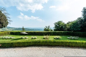 A well-maintained garden with neatly arranged outdoor seating and a clear view of the surrounding landscape. - Masaccio Apartament in Villa Guinigi (Capannori)