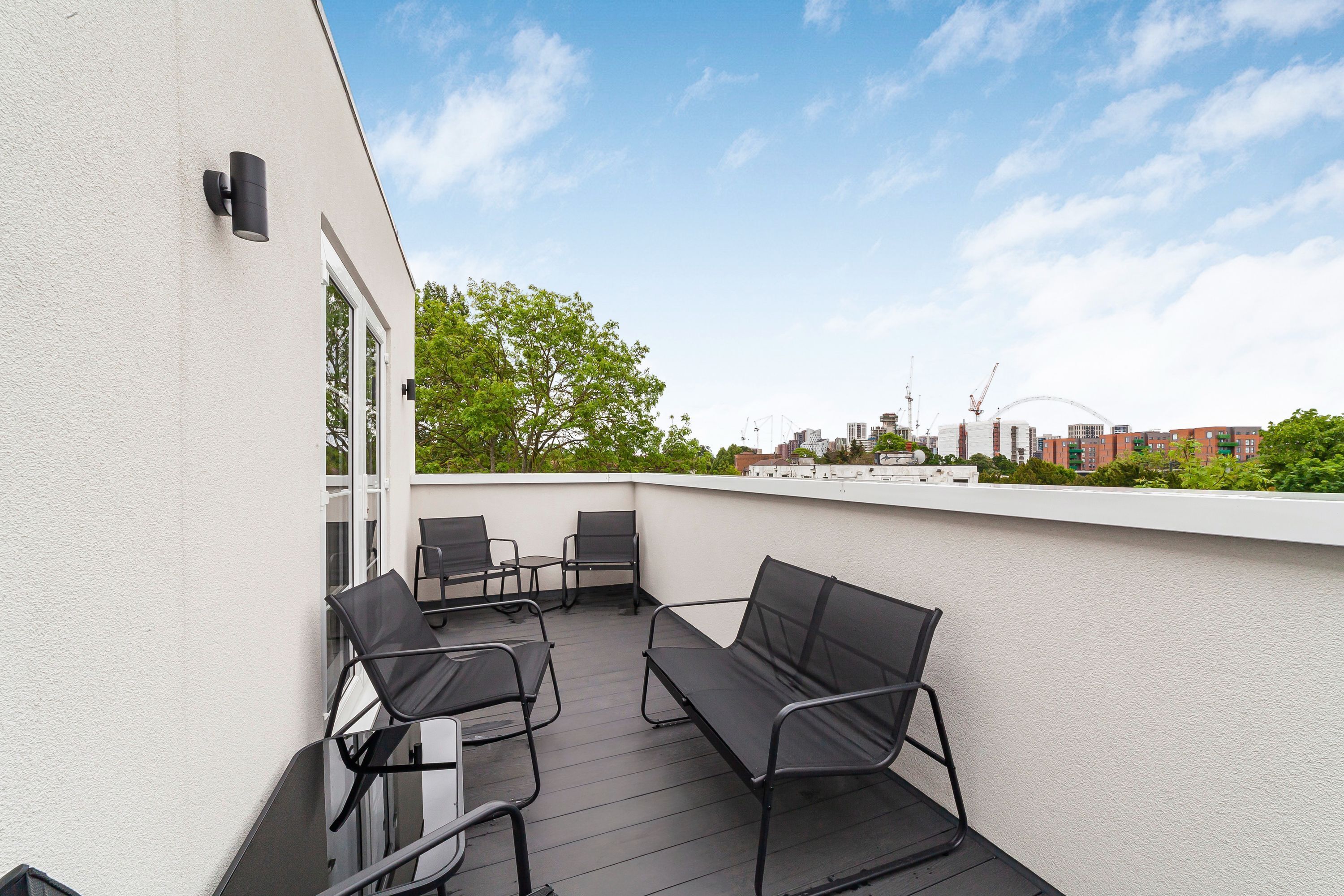 Eine Dachterrasse mit Sitzgelegenheiten und Blick auf die Stadt.