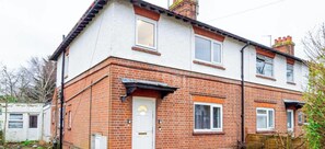 A two-story residential building with a brick facade, a white door, and a small garden area. - Free Parking 1 Bedroom Flat Sleeps 4 Abingdon (Oxford)