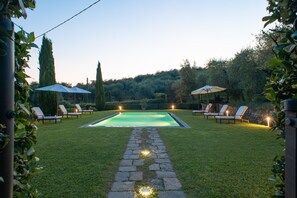 A swimming pool with a stone pathway leading to it, surrounded by grass and trees. - Villa di Buona Speranza - Oasis of Serenity (Lucca)