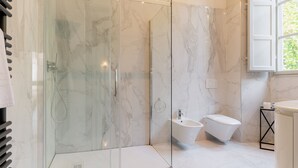 A modern bathroom with a glass-enclosed shower, a bidet, and a toilet. - Tintoretto Superior Apartment in Historic Villa (Capannori)
