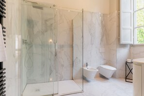 A modern bathroom with a glass-enclosed shower, a bidet, and a toilet. - Tintoretto Superior Apartment in Historic Villa (Capannori)