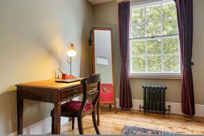 A room with a wooden desk, a chair, a mirror, a radiator, and a window with curtains. - Luxury 1820s Georgian Home 5-min Walk to Station (London)