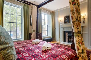 A bedroom with a large bed, a fireplace, and a view of the outside. - Luxury 1820s Georgian Home 5-min Walk to Station (London)