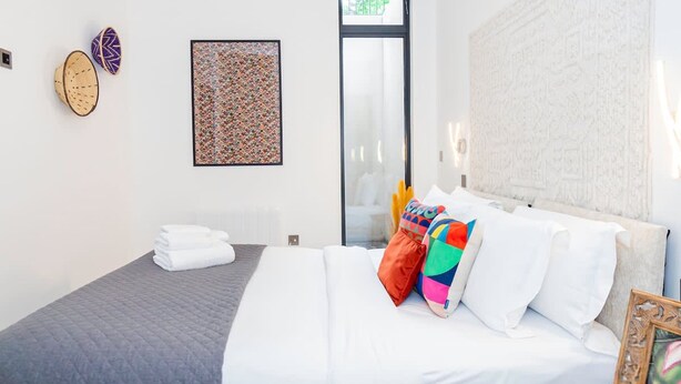 A modern hotel room with a bed, a large window, and a patterned wall. - Modern Luxurious Retreat in Acton w Great Links (London)